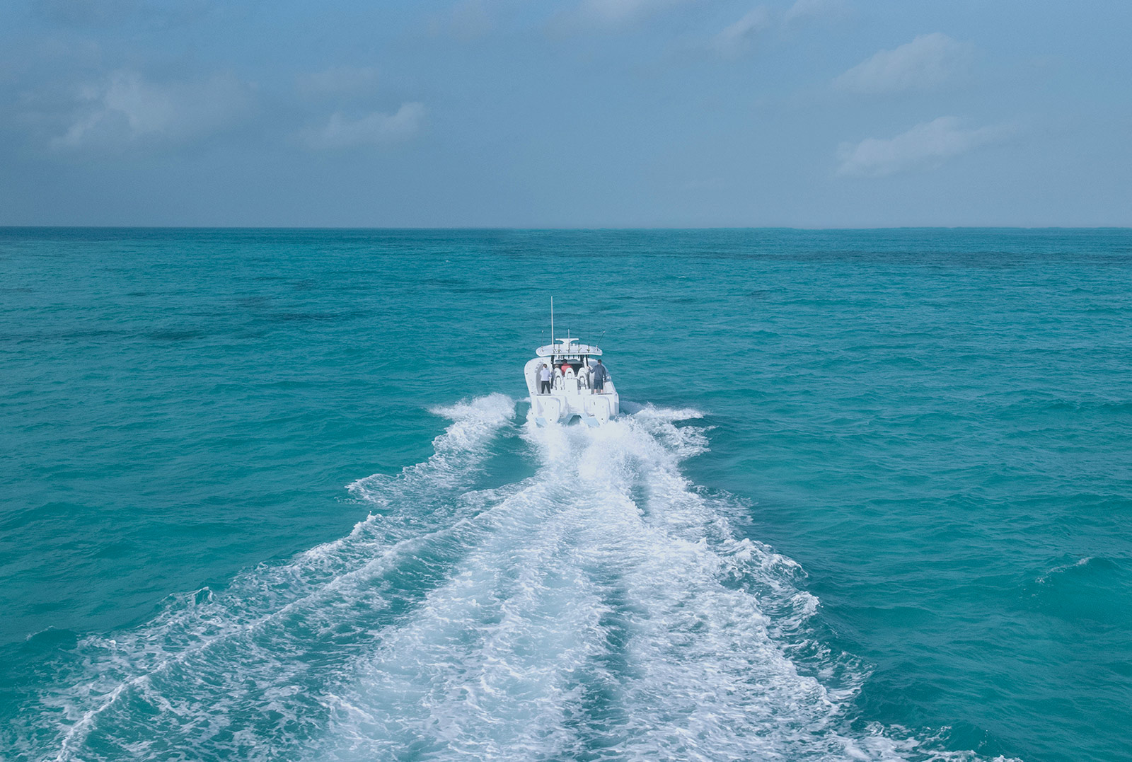 Outboard-powered boat underway in turquoise water